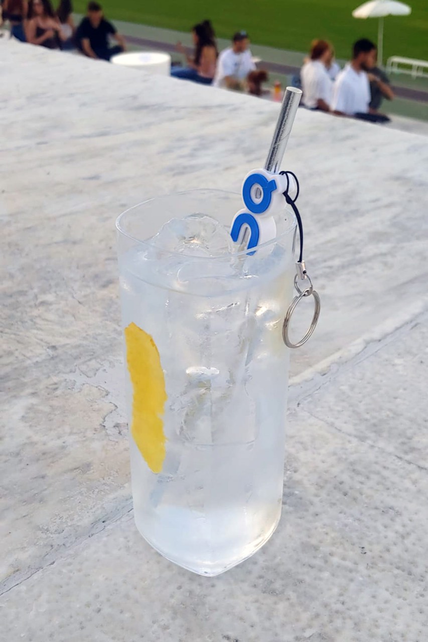 Charm con il logo On Cloud stampato in 3D agganciato a una cannuccia, gadget per evento